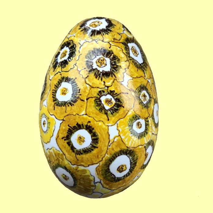 Blomstermaleri med gule aurikler. Malet med tusch på gåseæg. Efter malingen er ægget lakeret 3 gange. Den klare lak tilfører en delikat overflade, som kinesisk porcelæn. Der er sat en kraftig sytråd i æggets top, så det kan hænges op